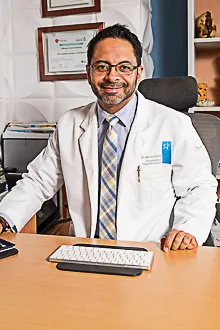 traumatologo_consultorio_dr_alfonso_alfonso_garcia_solorio_queretaro_220x330 Retrato del Dr. Alfonso Garcia Solorio en su consultorio, con bata blanca y expresion profesional.